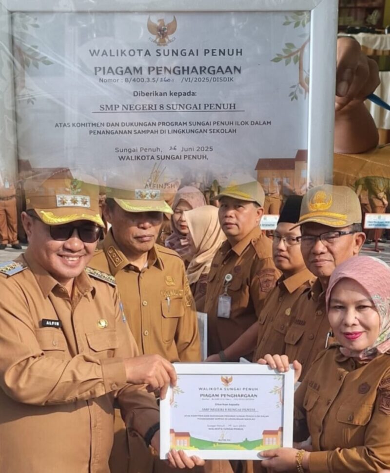 Wali Kota Sungai Penuh, Alfin, S.H., menyerahkan piagam penghargaan kepada Kepala SMPN 8, Elna Hasmita, S.Pd., M.M., atas komitmen menjaga kebersihan