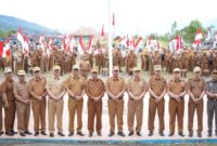 Bupati Kerinci Monadi menyerahkan bendera Merah Putih secara simbolis kepada perwakilan peserta pada upacara dan apel kerja di halaman Kantor Bupati Kerinci, Senin (11/8/2025)