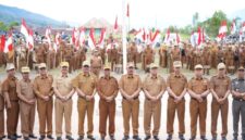 Bupati Kerinci Monadi menyerahkan bendera Merah Putih secara simbolis kepada perwakilan peserta pada upacara dan apel kerja di halaman Kantor Bupati Kerinci, Senin (11/8/2025)