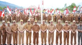 Bupati Kerinci Monadi menyerahkan bendera Merah Putih secara simbolis kepada perwakilan peserta pada upacara dan apel kerja di halaman Kantor Bupati Kerinci, Senin (11/8/2025)