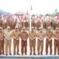 Bupati Kerinci Monadi menyerahkan bendera Merah Putih secara simbolis kepada perwakilan peserta pada upacara dan apel kerja di halaman Kantor Bupati Kerinci, Senin (11/8/2025)