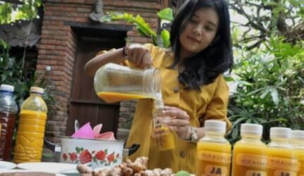 Anak-anak muda sedang minum jamu bersama di penjual jamu keliling saat mengikuti tren party jamu.