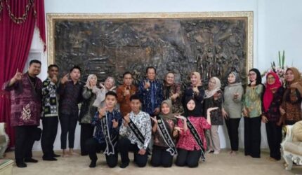 Foto rombongan peserta Bujang Gadis bersama pendamping dan perwakilan pemerintah daerah berpose di ruangan formal.