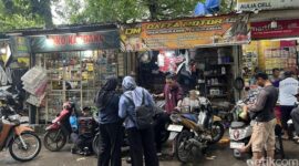 Seorang mekanik memperbaiki motor yang mogok setelah menerjang banjir di kawasan Jakarta Utara, Senin (12/1/2026).