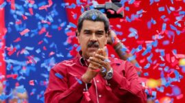 Presiden Venezuela tampil di hadapan pendukungnya saat sebuah acara politik, dengan konfeti berhamburan di latar belakang.