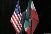 Bendera Amerika Serikat dan Iran dipajang dalam konteks pertemuan diplomatik, melambangkan ketegangan sekaligus upaya komunikasi antara kedua negara.