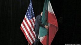 Bendera Amerika Serikat dan Iran dipajang dalam konteks pertemuan diplomatik, melambangkan ketegangan sekaligus upaya komunikasi antara kedua negara.