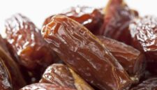 Tampilan kurma Tunisia jenis deglet nour yang memiliki warna cokelat keemasan, permukaan halus, dan daging buah semi-transparan.