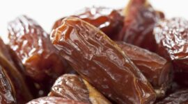 Tampilan kurma Tunisia jenis deglet nour yang memiliki warna cokelat keemasan, permukaan halus, dan daging buah semi-transparan.