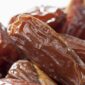 Tampilan kurma Tunisia jenis deglet nour yang memiliki warna cokelat keemasan, permukaan halus, dan daging buah semi-transparan.