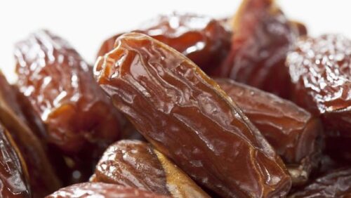 Tampilan kurma Tunisia jenis deglet nour yang memiliki warna cokelat keemasan, permukaan halus, dan daging buah semi-transparan.