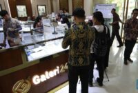 Sejumlah pengunjung melakukan transaksi pembelian emas batangan di Galeri 24