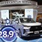 Pengunjung melihat Toyota Veloz Hybrid 2026 di showroom sambil membaca informasi harga dan estimasi pajak tahunan mobil hybrid tersebut.