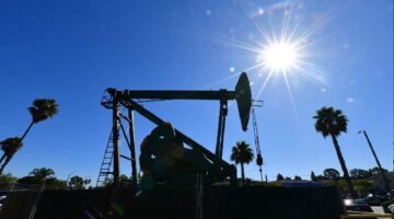 Pompa minyak beroperasi di tengah cuaca cerah, mencerminkan dinamika industri energi global di tengah fluktuasi harga minyak dunia.( Foto: AFP)