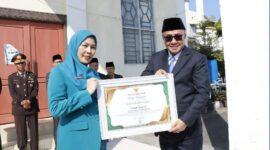Wali Kota Sungai Penuh, Alfin, menyerahkan penghargaan kepada Ketua TP PKK Sri Kartini Alfin sebagai penggagas Gerakan 3S dalam apel Hari Kebangkitan Nasional 2026.