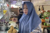 Bude Puji melayani pembeli sekaligus membagikan nasi gratis kepada penumpang dan pedagang di Pelabuhan Bakauheni.