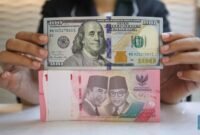 Petugas menghitung uang rupiah dan dolar AS, mencerminkan pelemahan nilai tukar rupiah terhadap dolar AS.(Fhoto CNBC Indonesia/Faisal Rahman)
