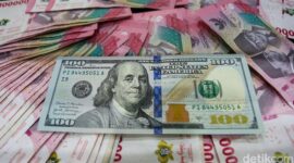 Lembaran uang dolar Amerika Serikat pecahan 100 dolar berada di atas tumpukan uang rupiah, menggambarkan penguatan dolar AS terhadap rupiah di pasar keuangan.(Ilustrasi/Foto: Gilang Faturahman/detikFoto)