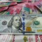 Lembaran uang dolar Amerika Serikat pecahan 100 dolar berada di atas tumpukan uang rupiah, menggambarkan penguatan dolar AS terhadap rupiah di pasar keuangan.(Ilustrasi/Foto: Gilang Faturahman/detikFoto)