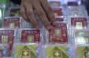 Petugas melayani pembeli dalam transaksi jual beli emas Antam di butik logam mulia.