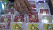Petugas melayani pembeli dalam transaksi jual beli emas Antam di butik logam mulia.