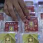 Petugas melayani pembeli dalam transaksi jual beli emas Antam di butik logam mulia.