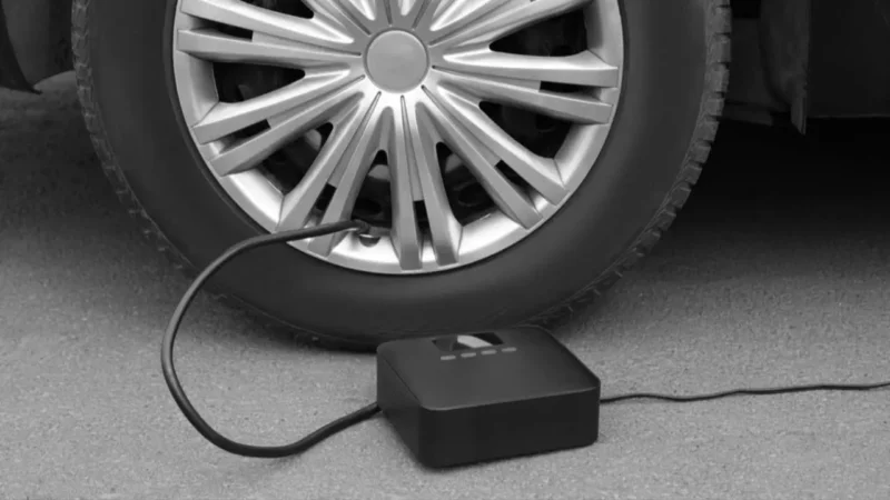 Pompa angin elektrik portable mengisi ban mobil di jalan(NewAfrica/Depositphotos)
