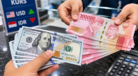 Ilustrasi Petugas menunjukkan uang rupiah saat transaksi penukaran dengan dolar AS di counter bank.