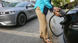 Pemilik mengisi daya mobil listrik menggunakan perangkat pengisian daya di rumah.(Foto : Liputan6.com/Fery Pradolo)