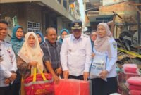Wali Kota Sungai Penuh Alfin menyerahkan bantuan kepada warga terdampak kebakaran di Desa Pasar Baru Sungai Penuh, Rabu (7/10/2026).(Foto : Prokopim Kota Sungai Penuh)