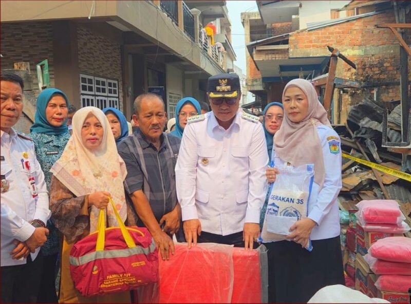Wali Kota Sungai Penuh Alfin menyerahkan bantuan kepada warga terdampak kebakaran di Desa Pasar Baru Sungai Penuh, Rabu (7/10/2026).(Foto : Prokopim Kota Sungai Penuh)